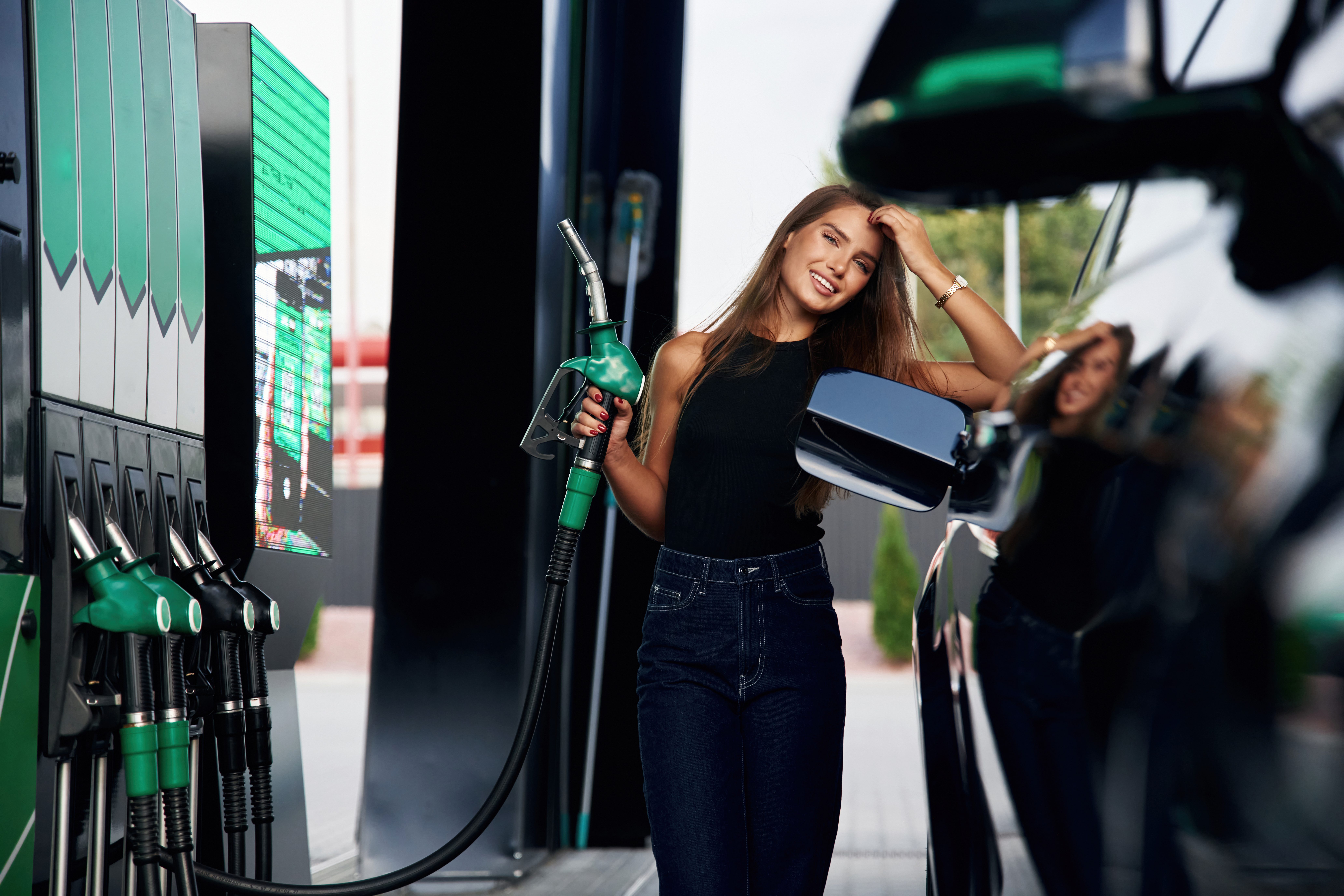 Ready to refill the automobile. A young woman at a gas station with her car Durchdenken aller Risiken, Vorteile und Kosten.